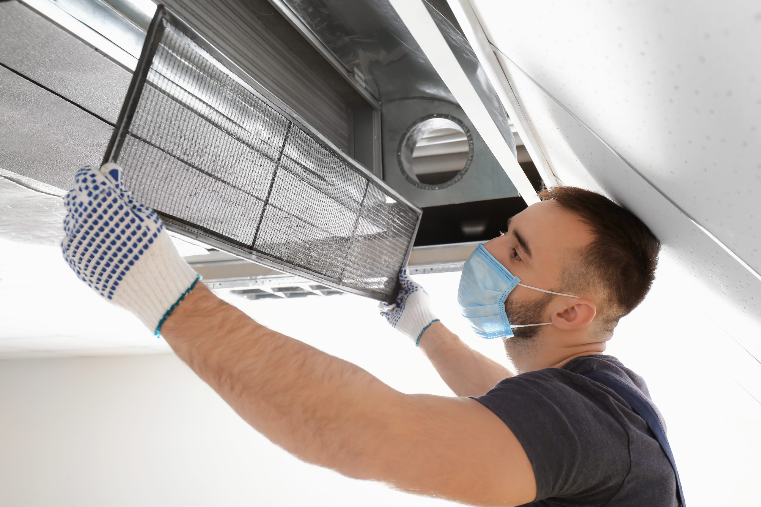A Man Checking the Air Conditioner Filter | Ductwork | A Plus Air Conditioning and Refrigeration