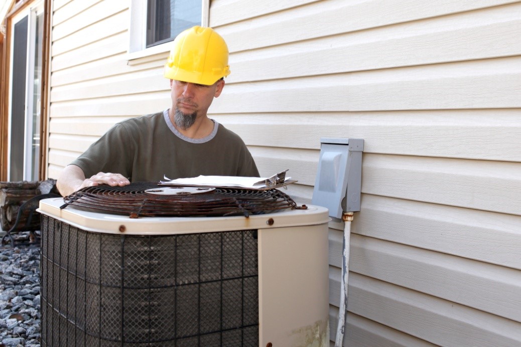 An HVAC technician checking a residential heat pump | Heat Pump