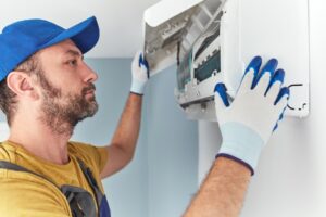 Technician man repairing Air Condition