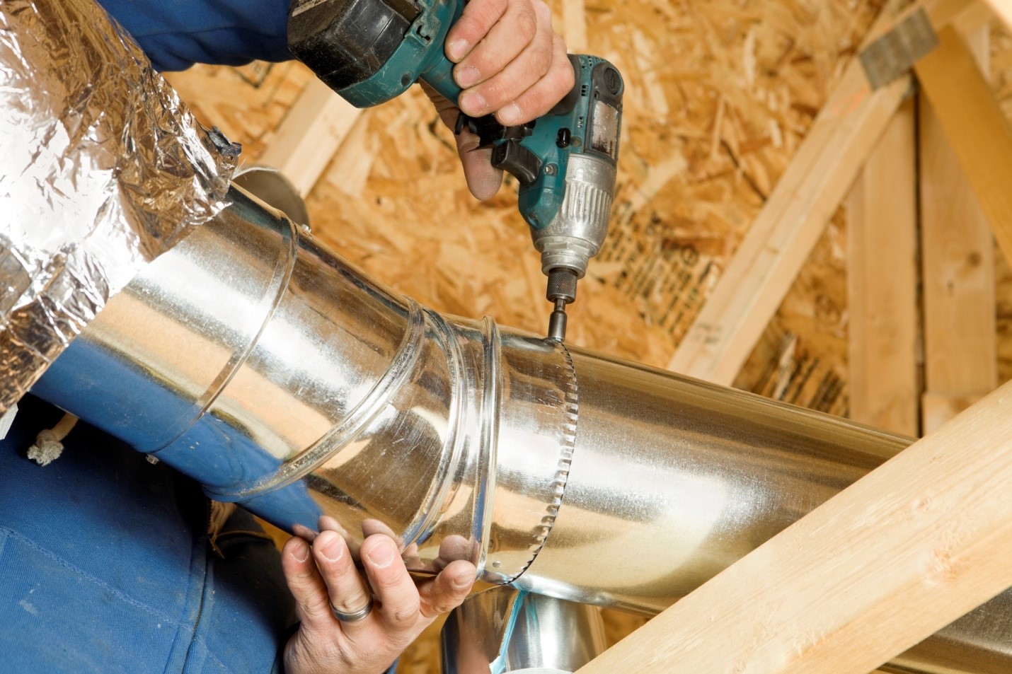 An HVAC expert drilling into air ducts | Air Ducts