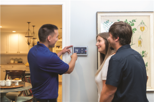 service tech showing a thermostat to home owner